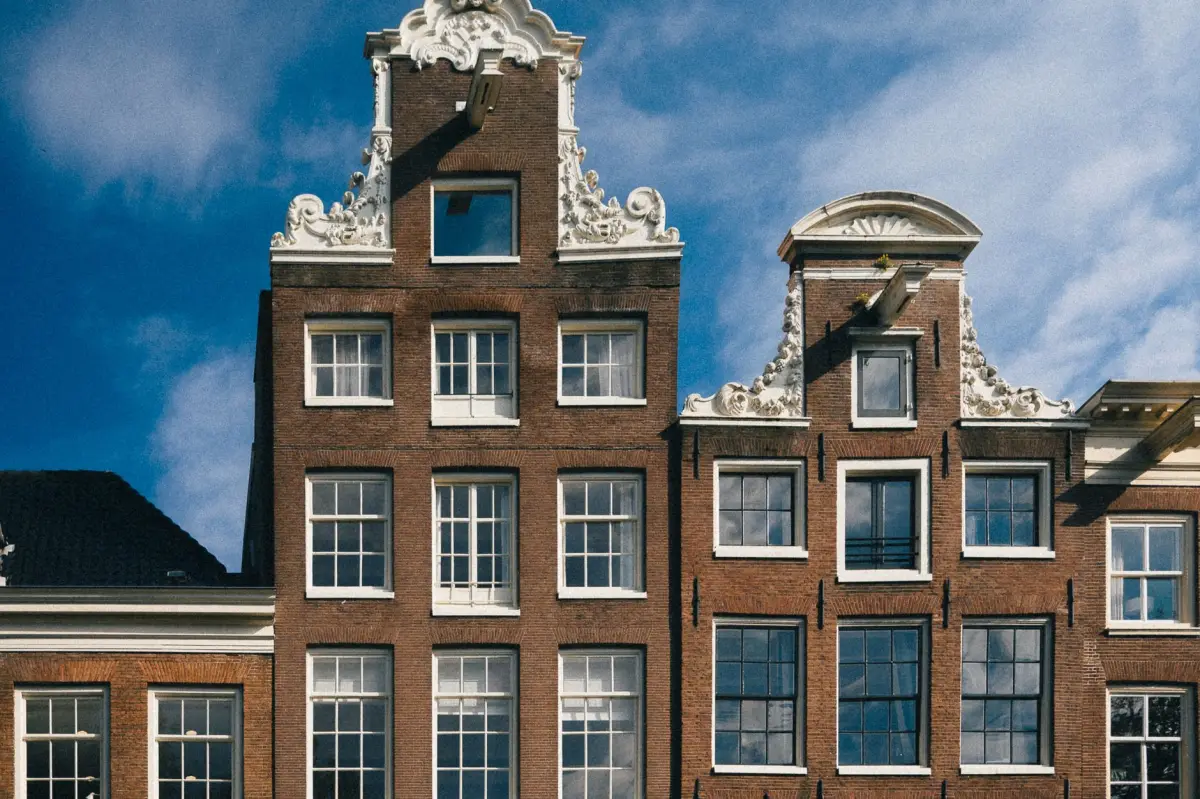Bakstenen gevel met witte houten kozijnen