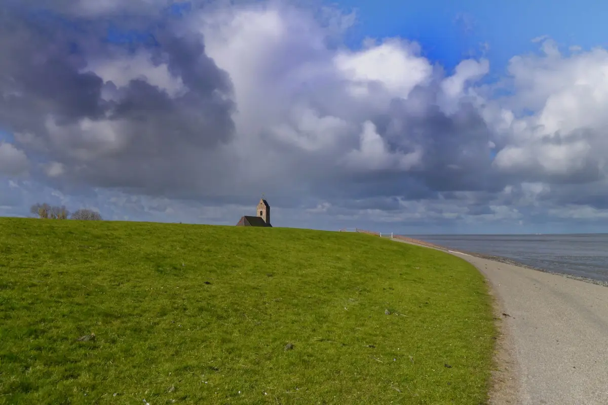 Zeedijk langs de kust met gras op het talud